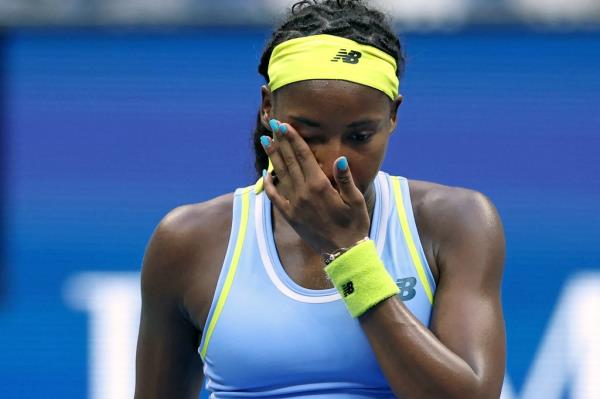 Coco Gauff wipes her face after losing to Emma Navarro in the 2024 U.S. Open.