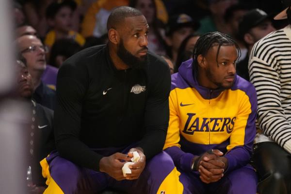 LeBron James and Bronny James sitting alongside each other on the bench.