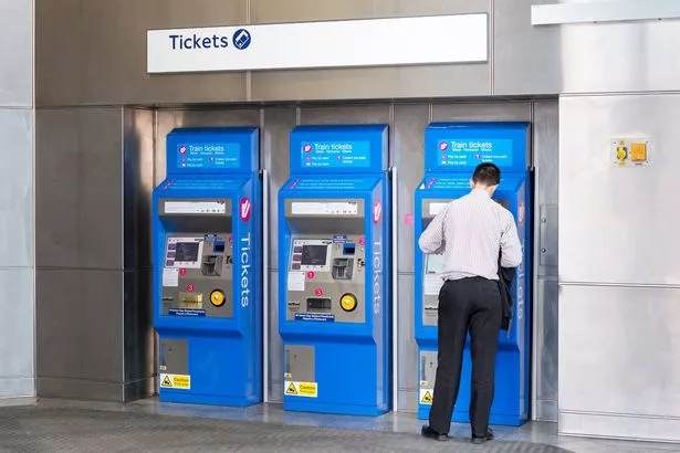 A customer using a ticket machine at a train station